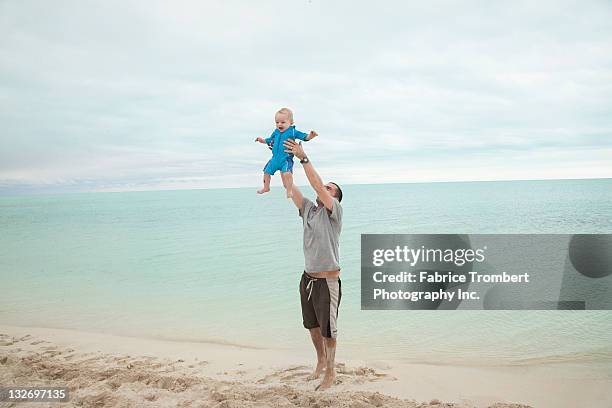 father throws baby up in the air - leap of faith stock pictures, royalty-free photos & images