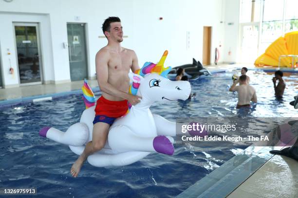 Mason Mount of England floats on an inflatable unicorn in the swimming pool at St George's Park on July 04, 2021 in Burton upon Trent, England.