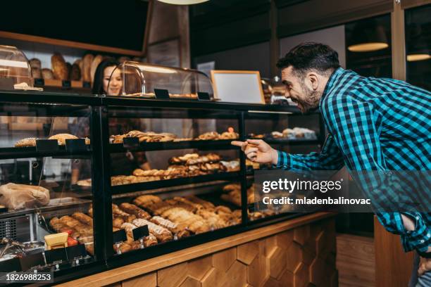 small business. woman assistant giving pastry to customer at bakery shop smiling happy - man offering bread stock pictures, royalty-free photos & images