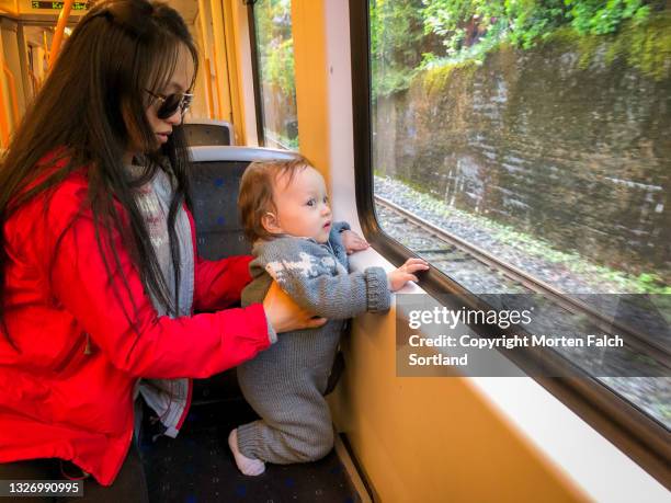 mother and child riding a train - oslo train stock pictures, royalty-free photos & images