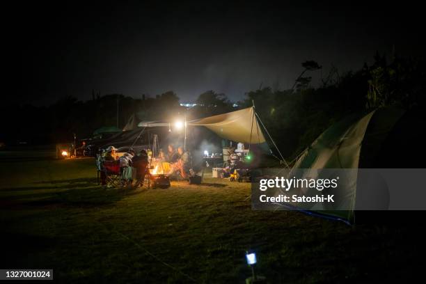 japanese families camping at night, enjoying dinner - tarpaulin 個照片及圖片檔