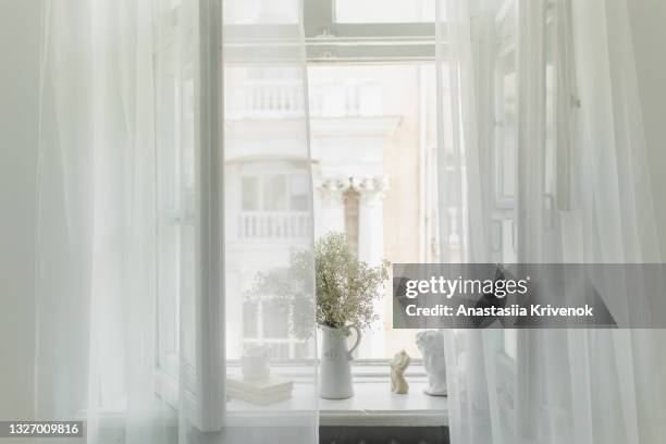 white room with curtain and and open window and vase of flowers on the windowsill. - tulle en matière textile photos et images de collection