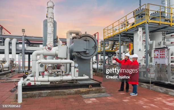 ingenieure und mitarbeiter kommunizieren vor ort in chemiewerk - oil refinery stock-fotos und bilder