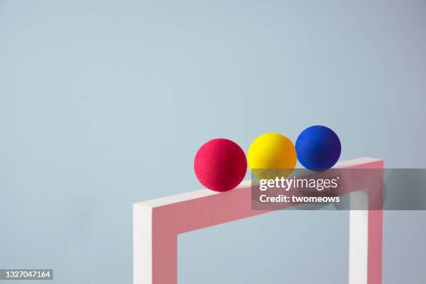 abstract minimalist coloured spheres balancing still life.. - y 3 fotografías e imágenes de stock