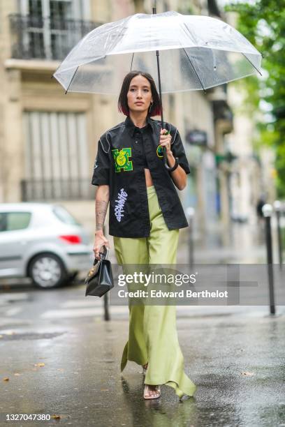 Alexandra Guerain wears a black crop-top, a black short sleeves shirt with green and yellow embroidered from Off-White, pale green shiny leather...