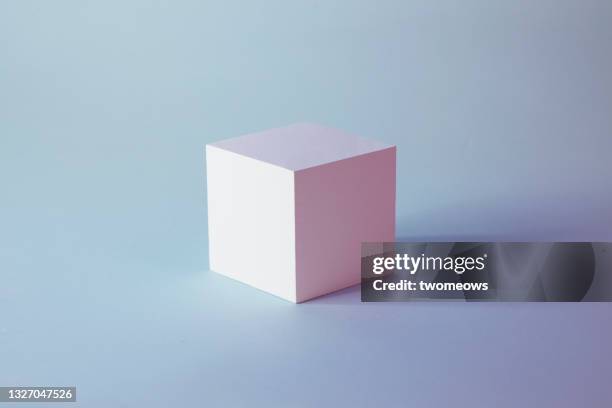 one white cube on blue background. - würfel stock-fotos und bilder