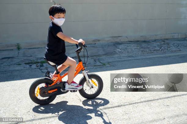 パンデミックでサイクリング - asian child with new glasses ストックフォトと画像