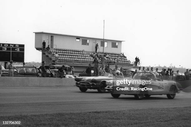 Two Chevrolet Corvette convertibles race each other during SCCA racing action at Daytona International Speedway.