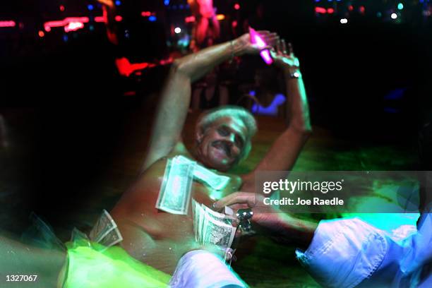 Year old Bernie Barker lays down on the stage as tip money is put into his G-string July 16, 2001 as he competes against other amateur strippers at...