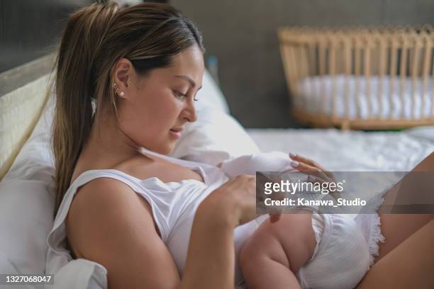 alleinerziehende mutter versucht, ihr baby in den schlaf zu setzen - baby depression stock-fotos und bilder