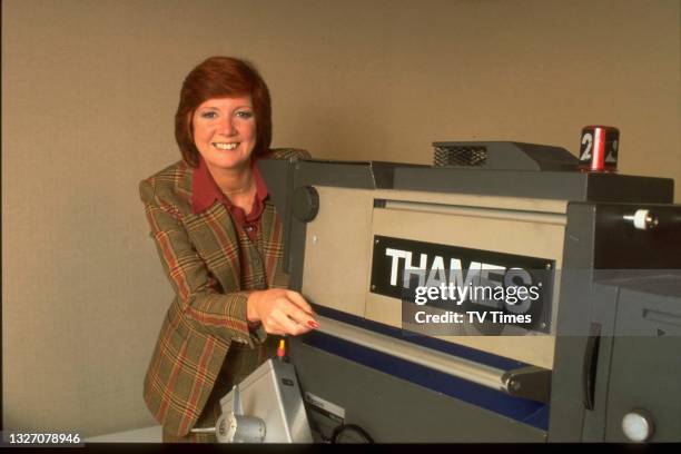 Presenter and singer Cilla Black standing with a television camera, circa 1978.