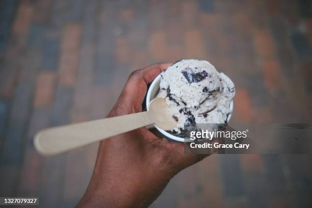 woman holds cup of cookies and cream ice cream - freezing hands stockfoto's en -beelden