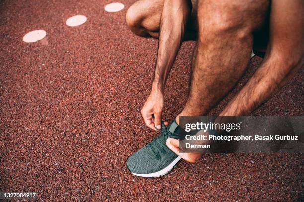 legs of male runner with smart watch, tying shoelaces - male feet stock-fotos und bilder