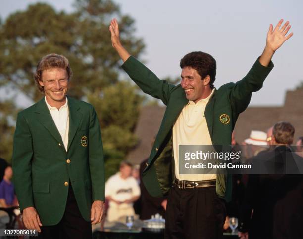Jose Maria Olazabal of Spain lifts his arms in celebration after being presented with his Green Jacket by Bernhard Langer of Germany, the previous...