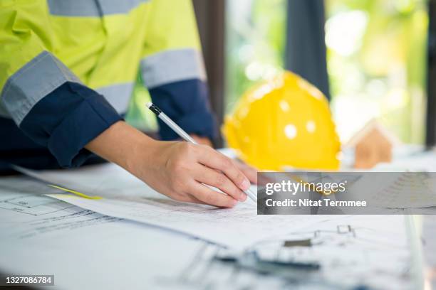 close-up shot of architect reviewing the blueprints construction plans on the office desk. architectural engineering concepts. - close up of blueprints stock pictures, royalty-free photos & images