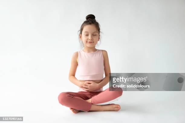 nettes mädchen tun atemübung - children yoga stock-fotos und bilder
