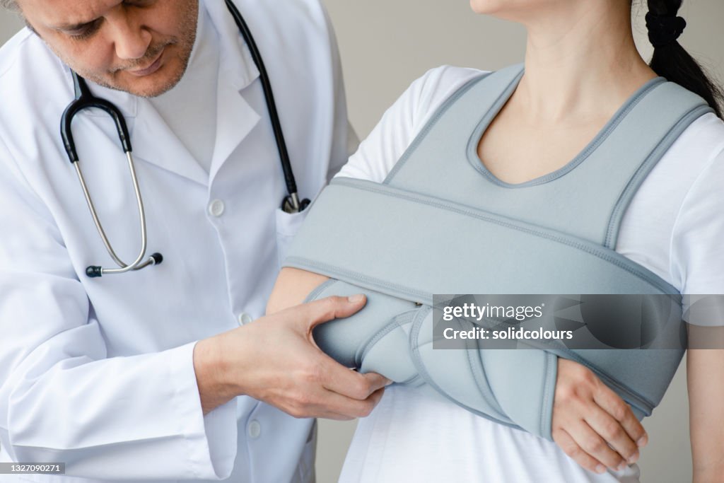 Doctor controlando el cabe cabezo del brazo de la mujer