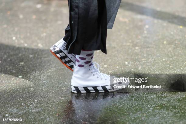 Guest wears a black long skirt, white and purple polka dots ribbed socks, white leather ankle sneakers with checkered sole from Off-White, a gold...