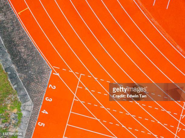 directly above drone point of view numbered starting line all weather track and field stadium in the morning - all weather running track stock pictures, royalty-free photos & images