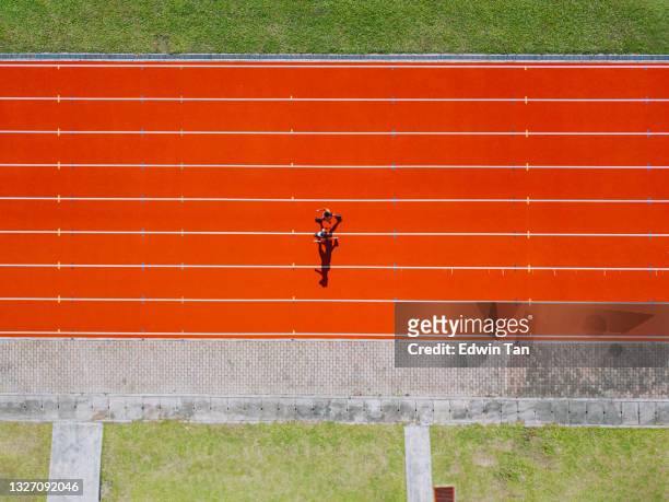 directly above drone point of view asian chinese father son running at track and run towards finishing line in the morning at track and field stadium beside bleachers - men's track 個照片及圖片檔