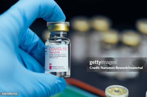the close-up image of the covid-19 bottle with the black backdrop - vaccino contro il covid 19 foto e immagini stock
