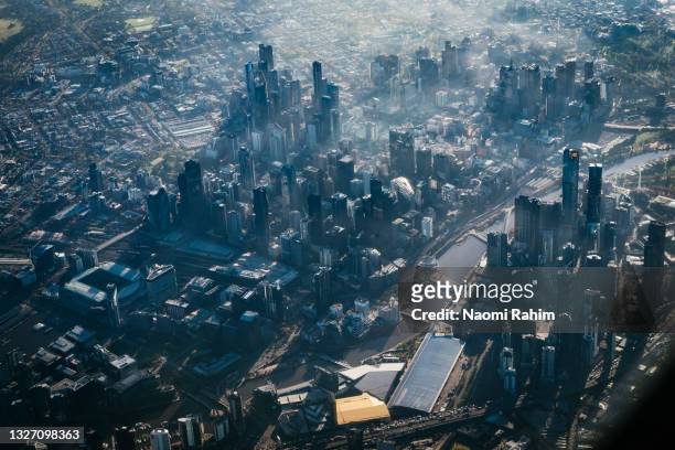 aerial view of melbourne city skyline in fog - docklands stadium melbourne stock pictures, royalty-free photos & images