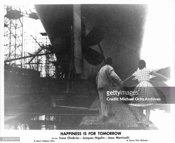 Jacques Higelin leading Irene Chabrier to hull of ship in a scene from the film 'Happiness Is For Tomorrow', 1961.