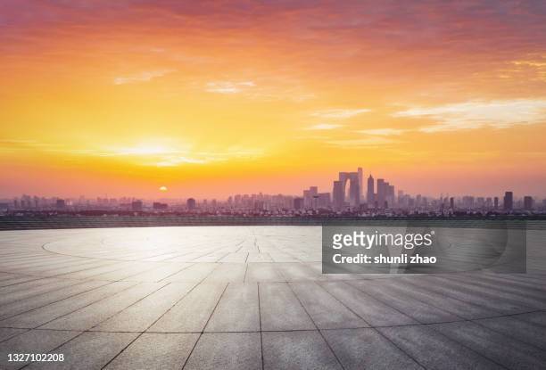 parking lot at sunrise with the city skyline as the background - circular business district stock-fotos und bilder