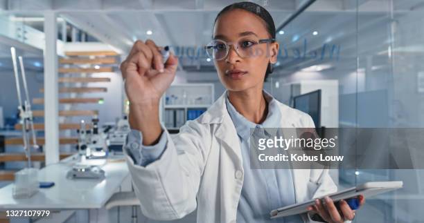 shot of a scientist solving equations on a glass screen in a laboratory - physics laboratory stock pictures, royalty-free photos & images
