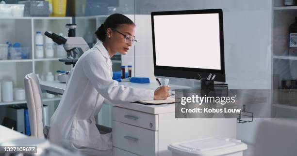 shot of a young scientist using a computer while conducting medical research in a laboratory - lab coat stock pictures, royalty-free photos & images