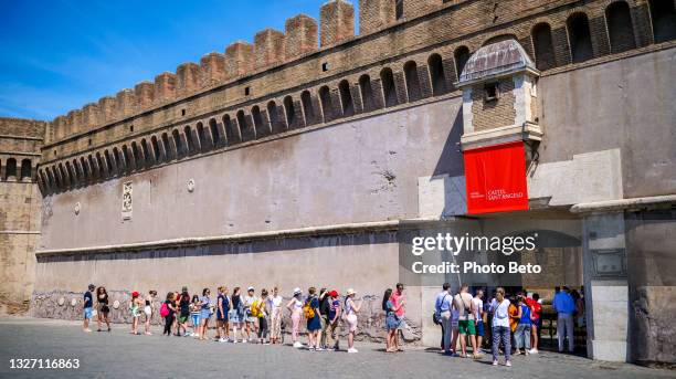 dozens of tourists wait in line to visit castel sant'angelo in the historic heart of rome - museum entrance stock pictures, royalty-free photos & images