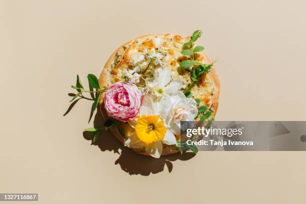 pizza with spring flowers on pastel beige background. creative food or natural concept. flat lay, top view. - art food stock pictures, royalty-free photos & images