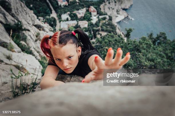 brave young girl with pink pigtails climbing in rock wall close up - extreme close up fotografías e imágenes de stock