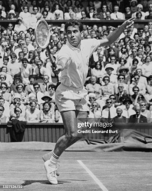 Manuel Santana of Spain reaches to play a return to Owen Davidson of Australia during their Men's Singles Semi Final match at the Wimbledon Lawn...