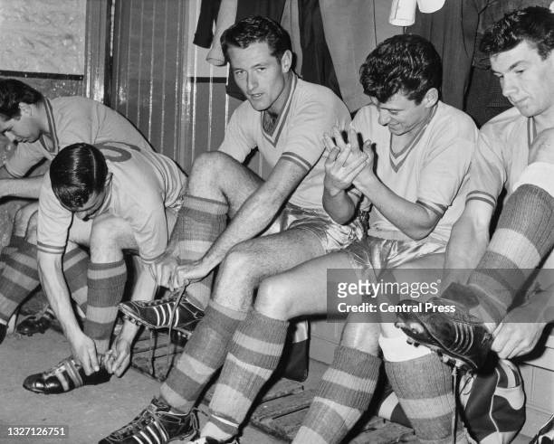 Tennis player Mike Sangster of Great Britain and outside left for English Third Division side Torquay United football club ties his football boot...