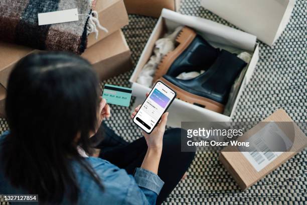overhead view of young woman doing online shopping with smart phone - credit card mockup stock pictures, royalty-free photos & images