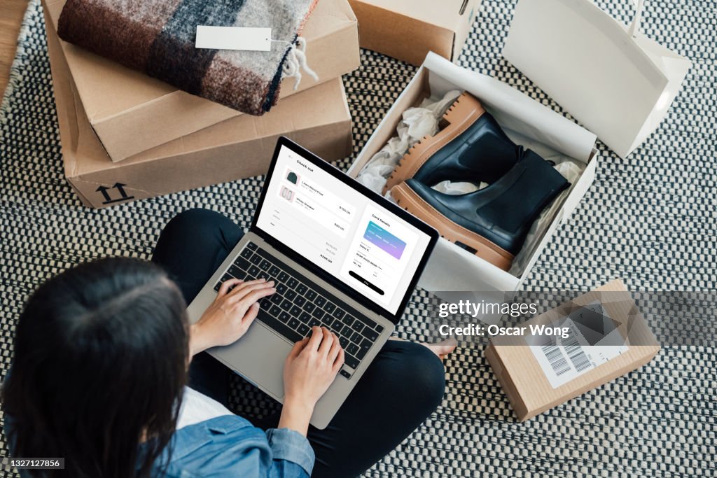 Overhead View Of Young Woman Doing Online Shopping With Laptop