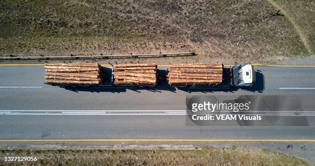 aerial view of a truck on the road carrying piles of cut logs - african lorry stock pictures, royalty-free photos & images