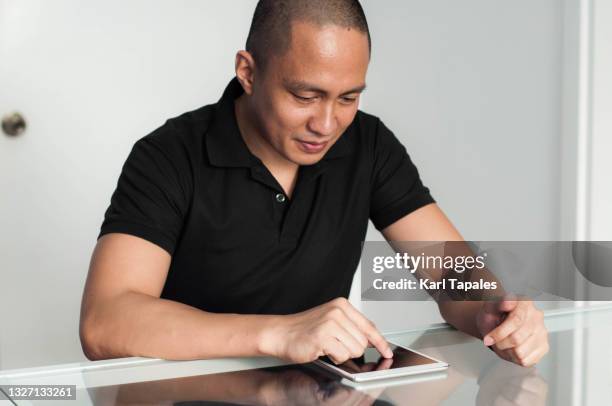 a young southeast asian man in the office is interacting with technology - daily life in philippines stock pictures, royalty-free photos & images