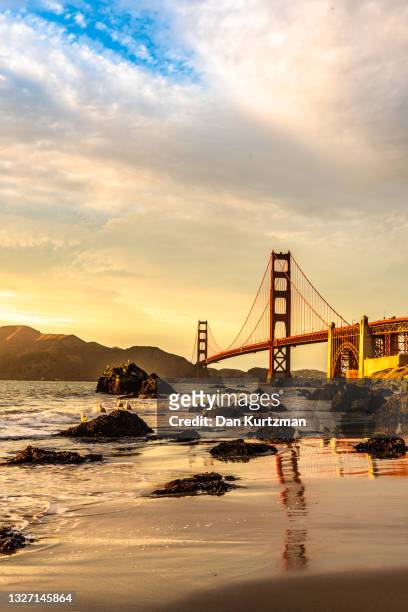 golden gate bridge and beach at sunset, san francisco - goldene stunde stock-fotos und bilder