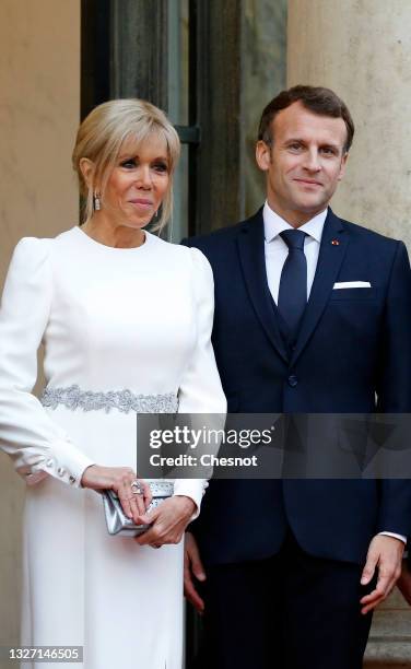 French President Emmanuel Macron and his wife Brigitte Macron stand side-by-side prior to a state dinner with Italian President Sergio Mattarella and...