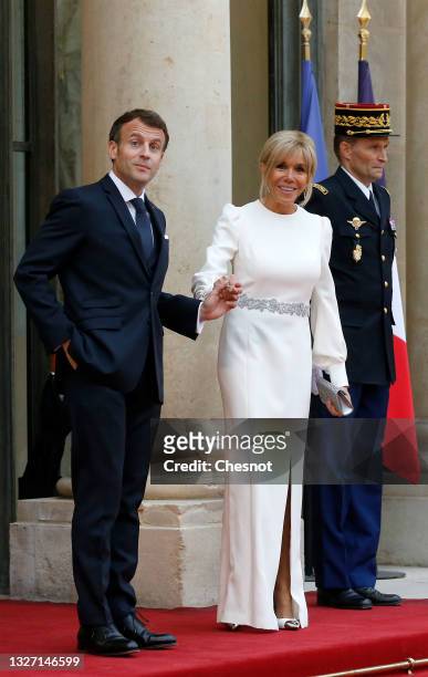 French President Emmanuel Macron and his wife Brigitte Macron stand side-by-side prior to a state dinner with Italian President Sergio Mattarella and...