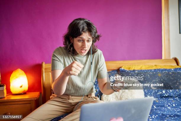 a young woman playing charades on a video call - pantomime stock pictures, royalty-free photos & images