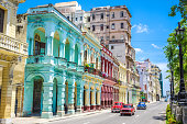 Multicolored old american classic cars on street of Havana against historic buildings