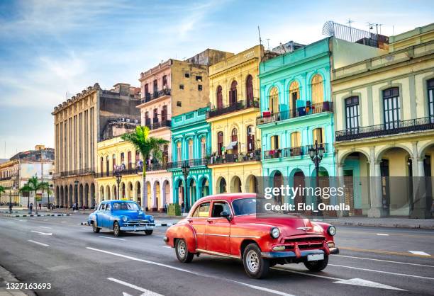 coches de taxi vintage multicolores en la calle de la habana contra edificios históricos - cuba fotografías e imágenes de stock