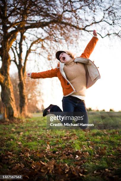 a young girl enjoys a park in seattle at sunset. - discovery park stock pictures, royalty-free photos & images