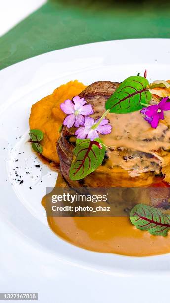 speck verpacktes steak mit süßkartoffeln in au jus in einem luxusrestaurant - kartoffelblüte nahaufnahme stock-fotos und bilder
