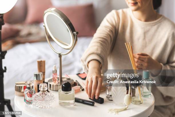 a woman's hand is reaching out to pick up a lipstick from a table full of beauty products - vintage hand mirror stock pictures, royalty-free photos & images