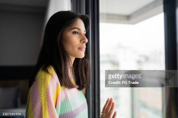 young woman contemplating at home - worry free stock pictures, royalty-free photos & images