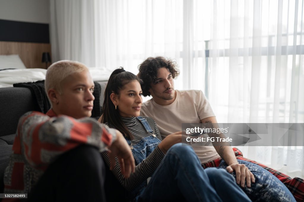 Friends watching tv together at home